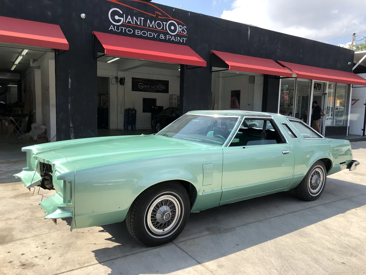 A mint green classic coupe outside Giant Motors