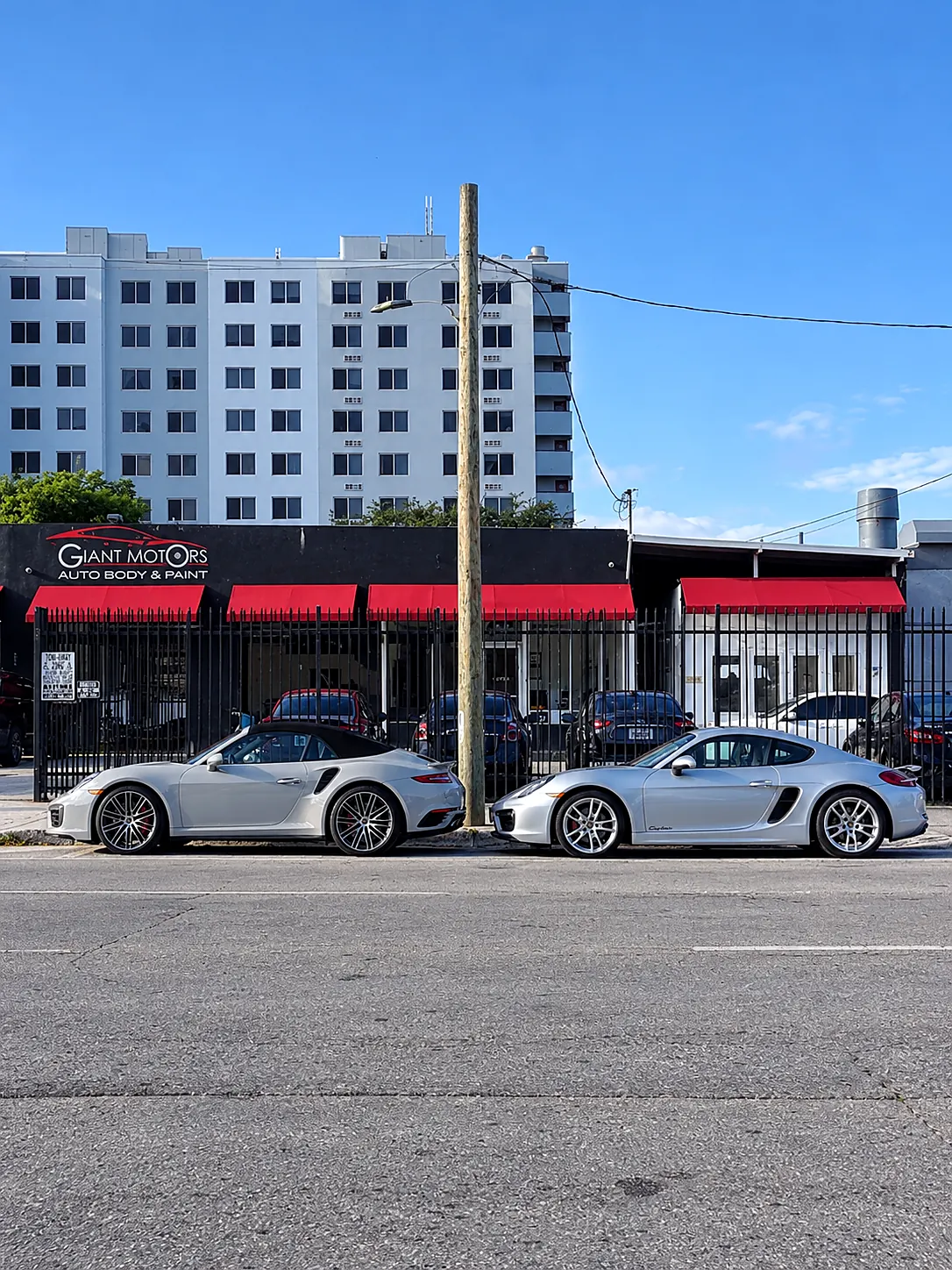 Two finished Porsches parked in front of Giant Motors on NW 5th Street