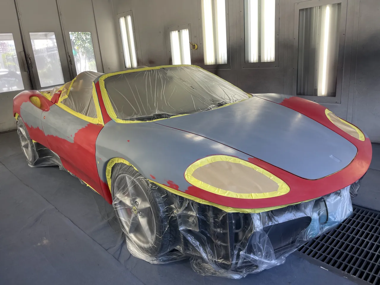 A Ferrari fully masked and primed for a complete respray in the paint booth