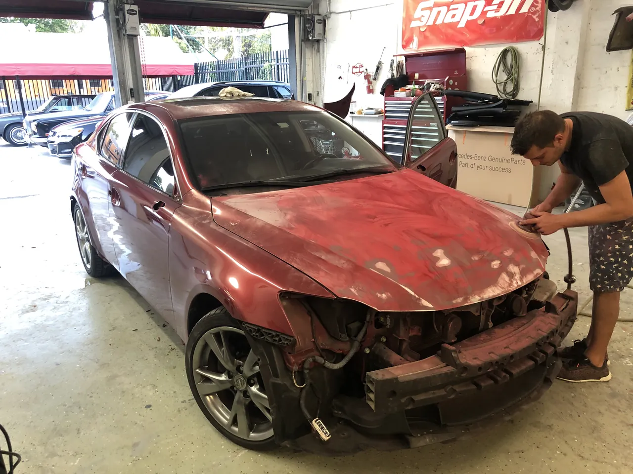 A Giant Motors technician fitting a front bumper on a damaged car